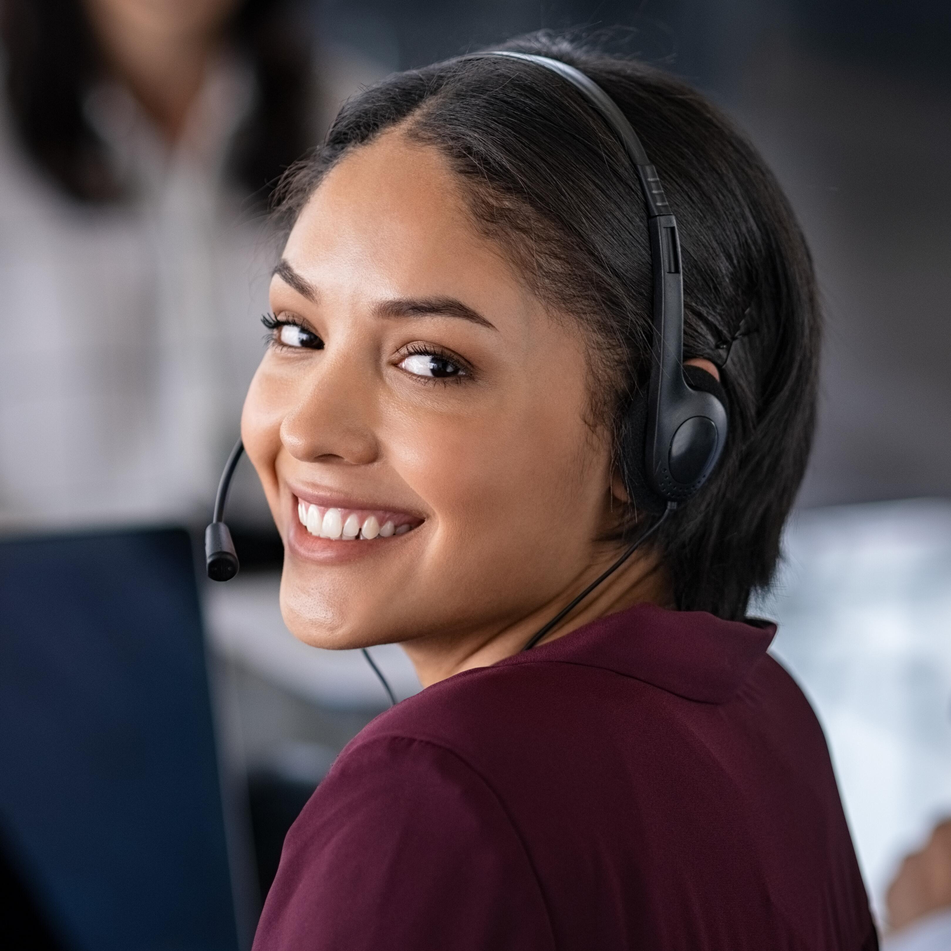 A smiling staff member wearing a headset
