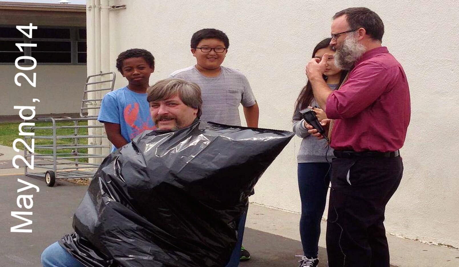 Mr. Marx getting a haircut by Mr. Sanders during recess. 