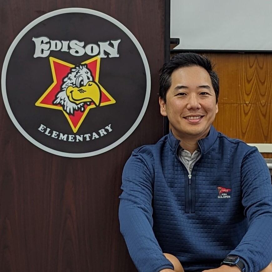 A photo of PTA President Steve Choi, sitting in front of the Edison Elementary logo.