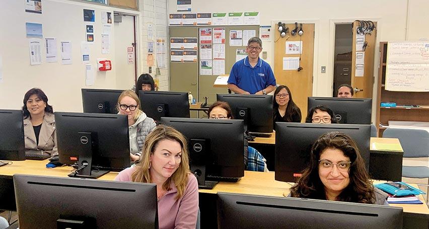 teacher with students in computer classroom